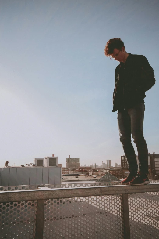 a man is balancing on a rail on a balcony