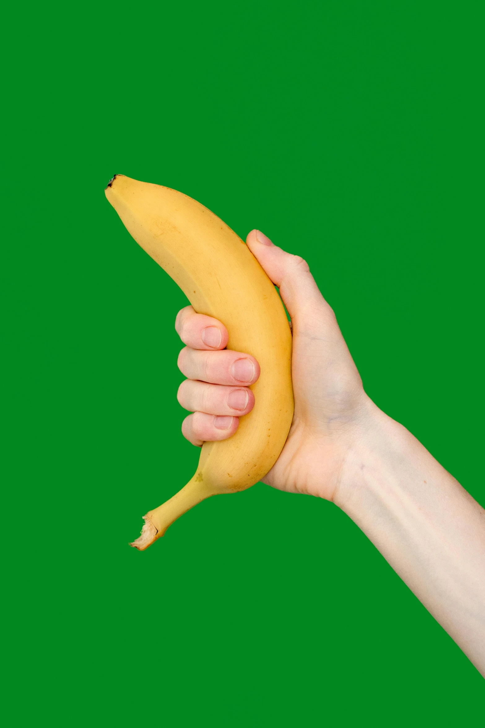 the person is holding up a yellow banana