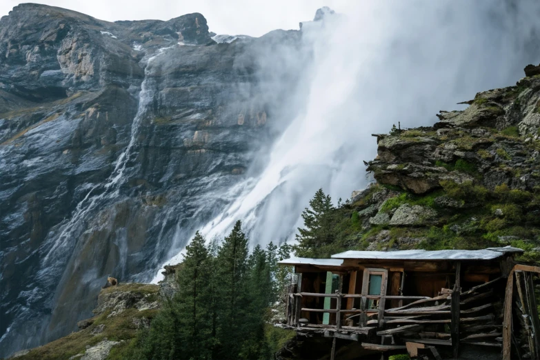 a tall waterfall towering over a forested mountain