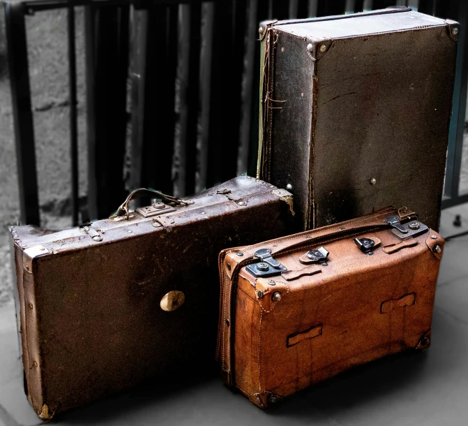 three suitcases on the ground with one unzipped