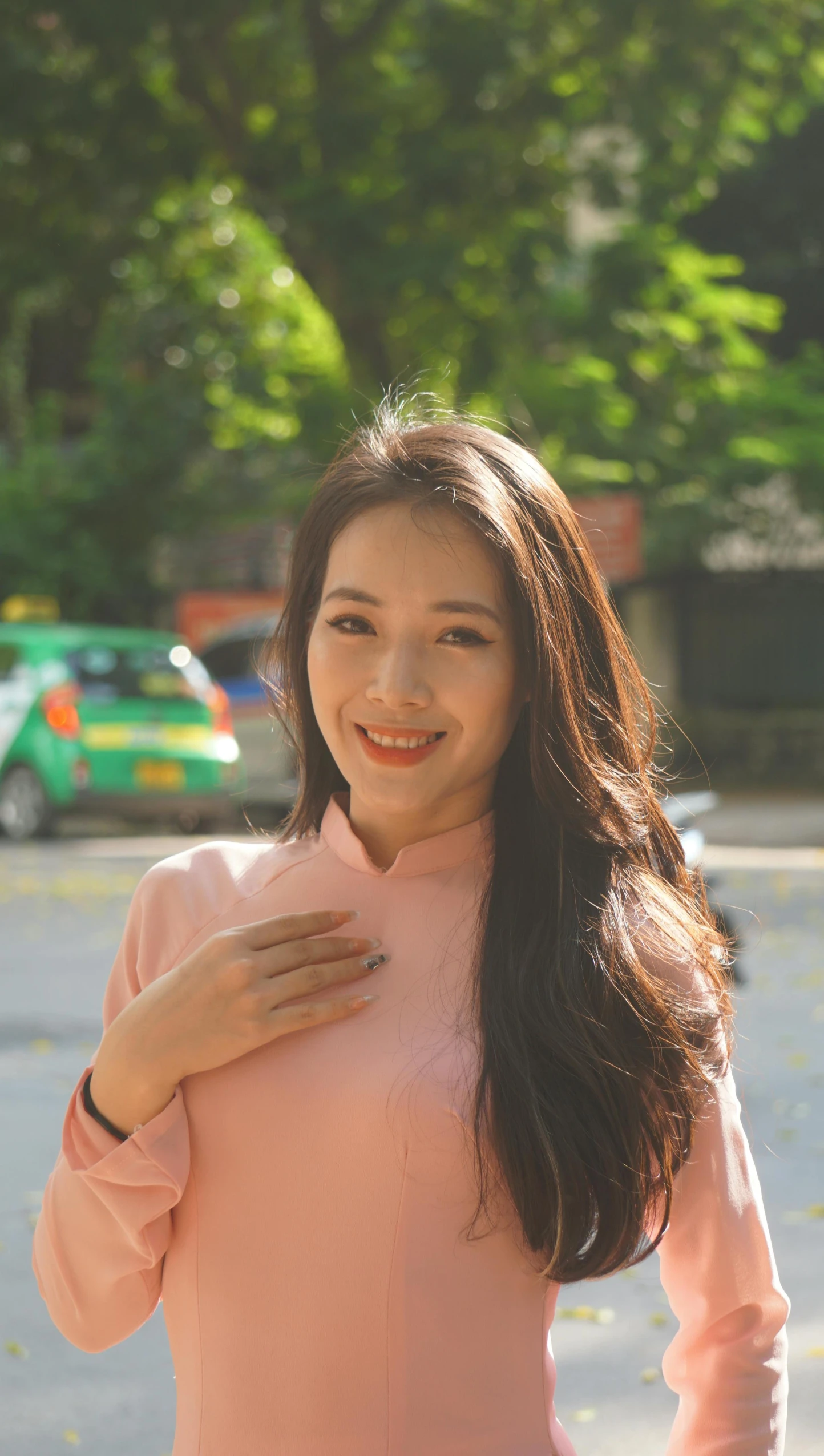 a woman wearing pink poses in a parking lot