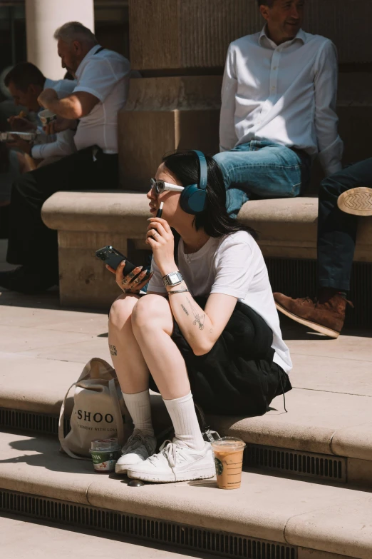 young woman sitting on steps while smoking