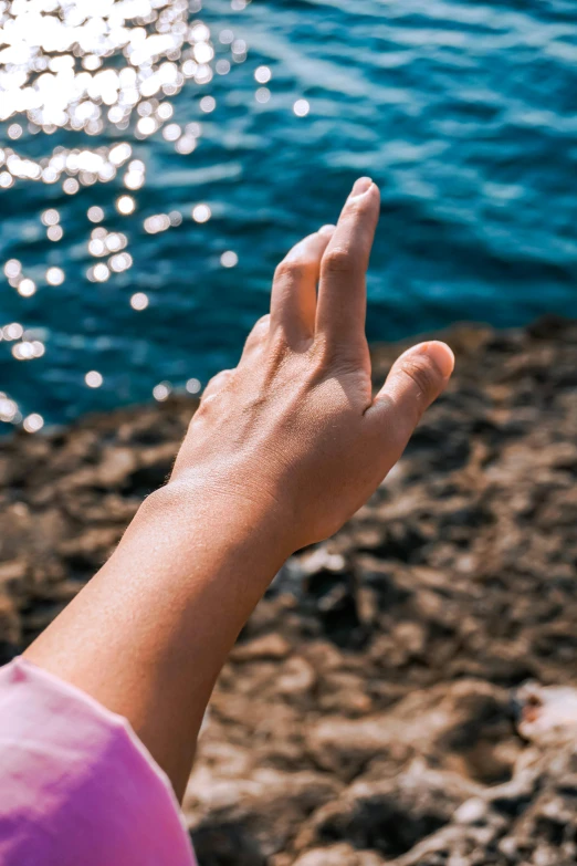 a person is pointing towards a body of water