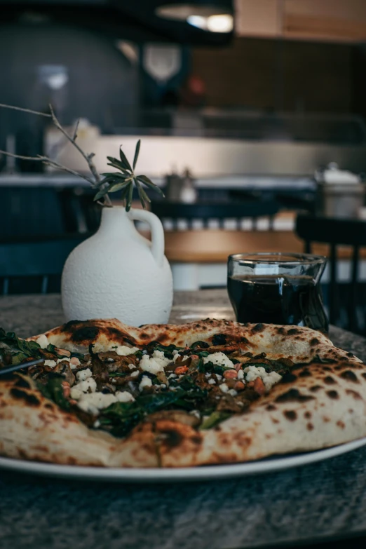 a plate full of pizza next to a vase with flowers