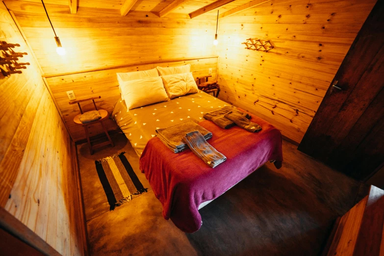 a room with a bed made and lights hanging above it