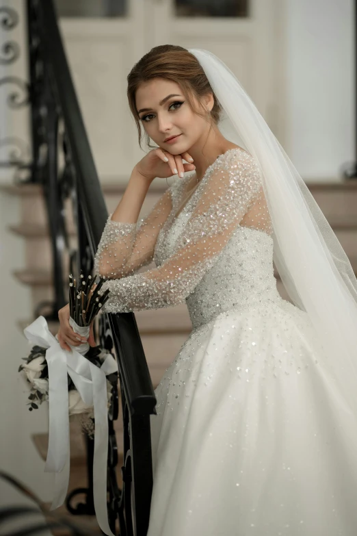 a woman in a wedding dress leaning on the stairs