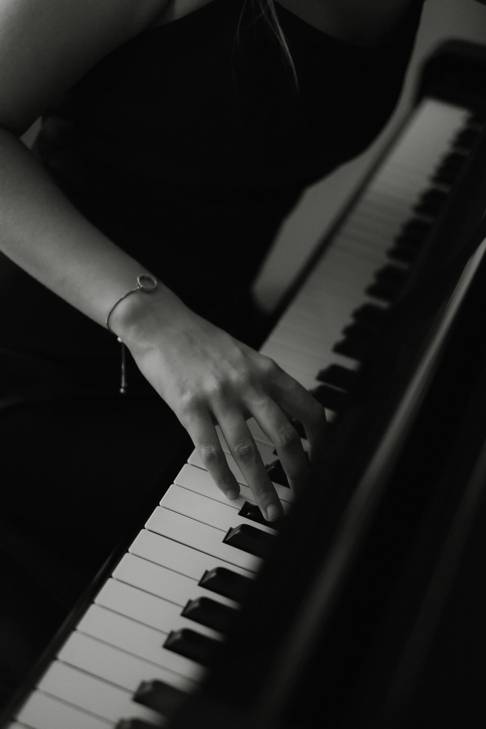 a person sitting at a piano with their hands on the keyboard