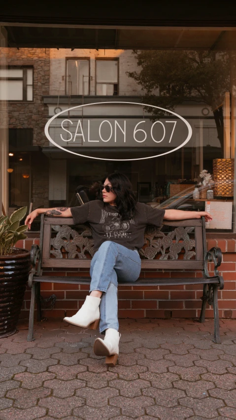 a woman sitting on a bench outside salon 86