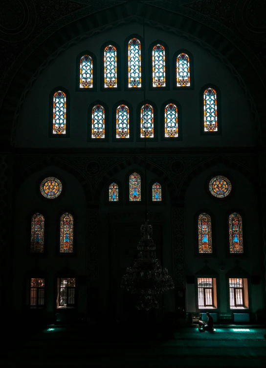 a dark room with three sets of stained glass windows
