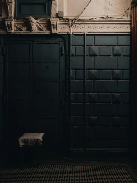 the door is black and dirty, with some sort of clock above it
