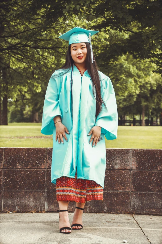 a young woman posing for a picture while wearing a cap and gown