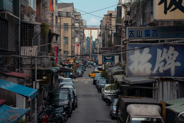 some cars are parked in the street by buildings