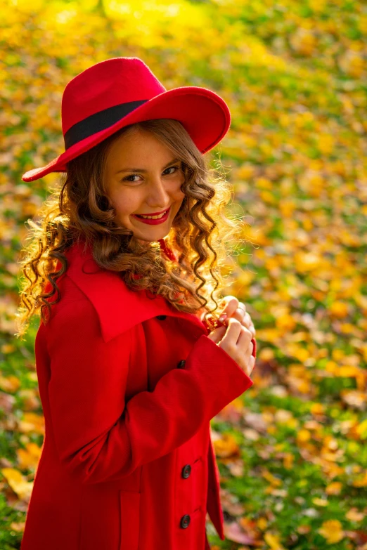 a smiling woman in a red coat and hat