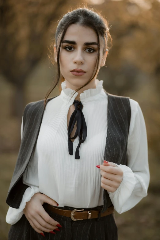 an attractive young woman in dress clothes poses for the camera