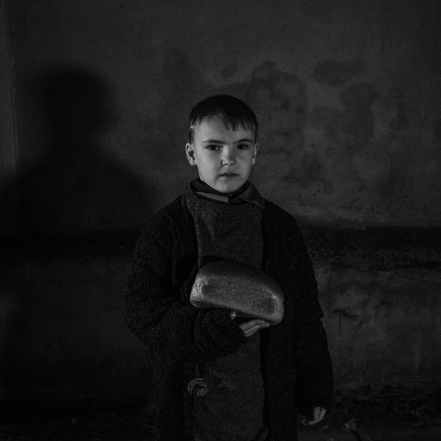 a boy holding an item in his right hand