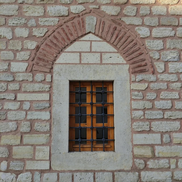 small window on brick wall with bars at the bottom