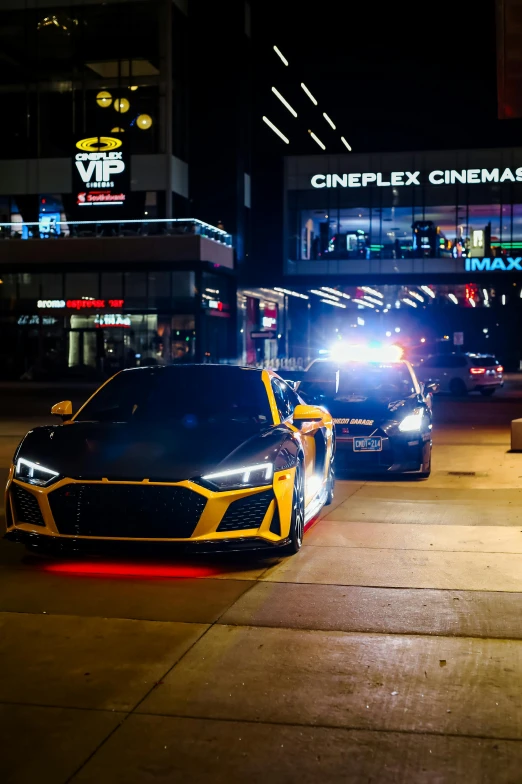 a police car sitting next to a sports car in the street