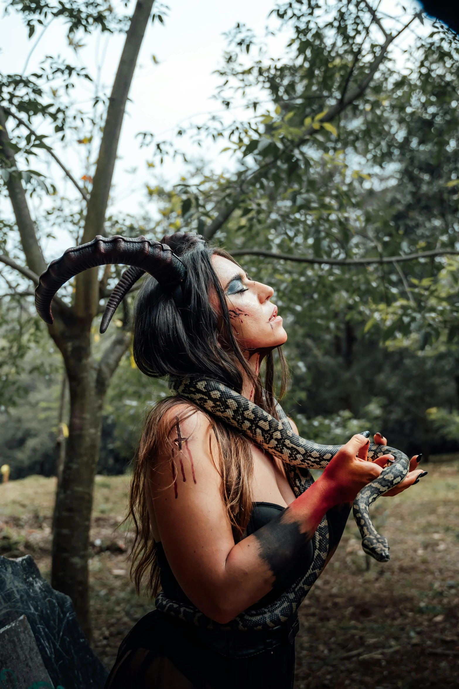 a woman in a costume holding a snake around her neck