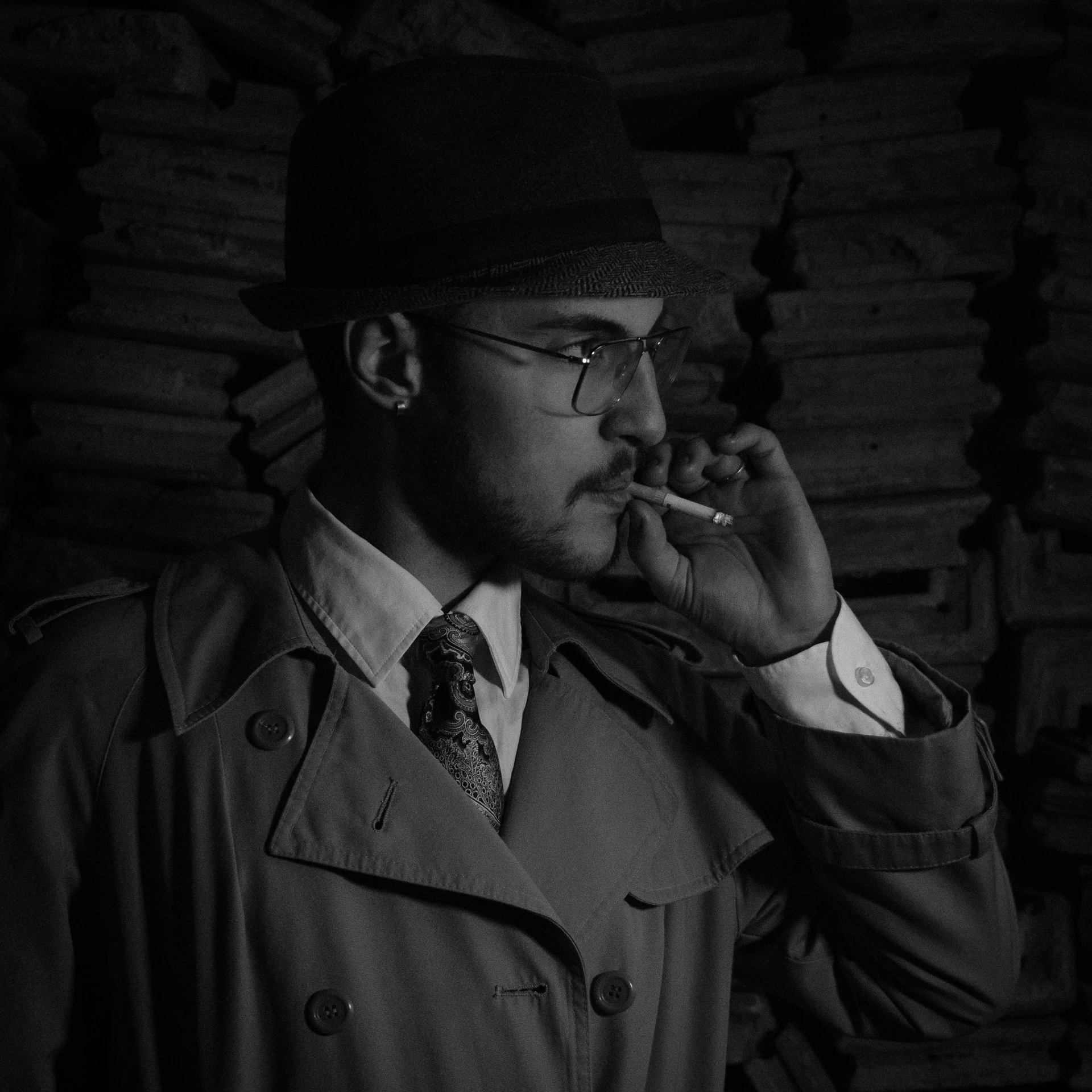 a man in a trench coat smoking a cigarette