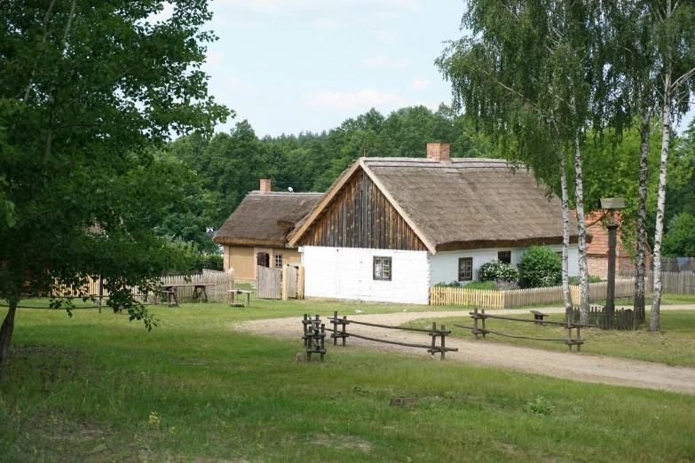 a thatched roofed home sits outside on the grass