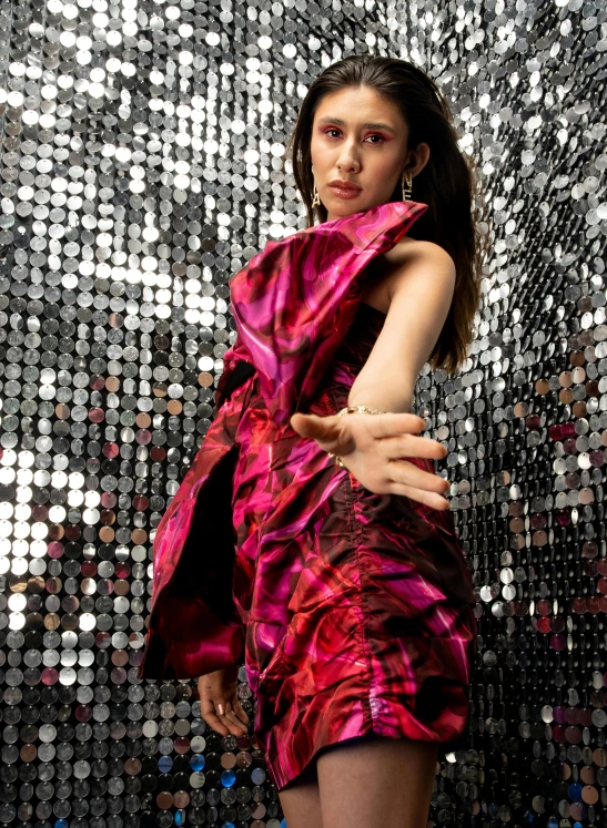 a woman wearing a red dress is in front of a disco backdrop