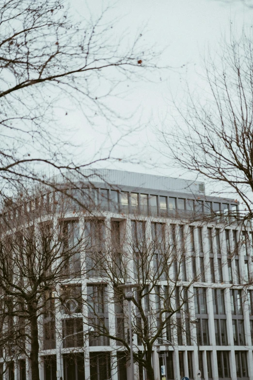 a tall building with a clock at the top in front of some trees