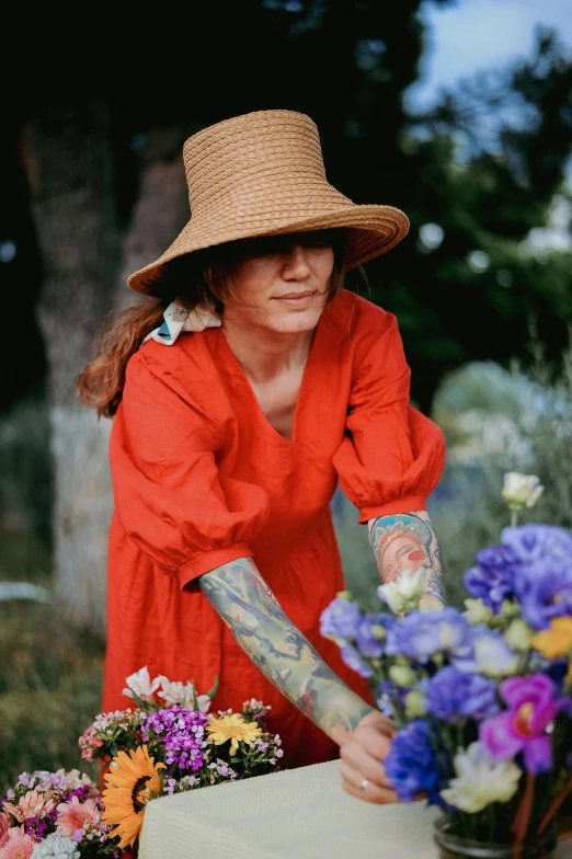 a woman with tattoos cuts up the flowers