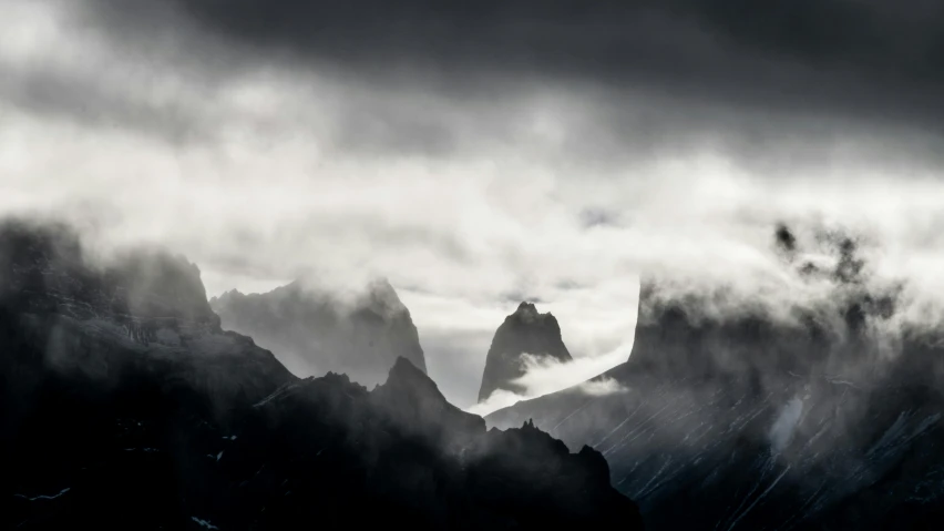 some large mountains with fog hanging over them