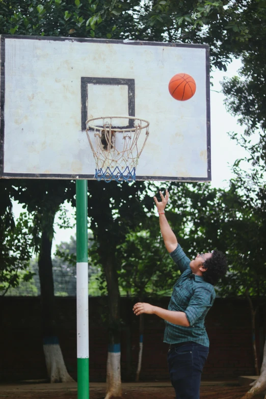 a young man is shooting the basketball for it