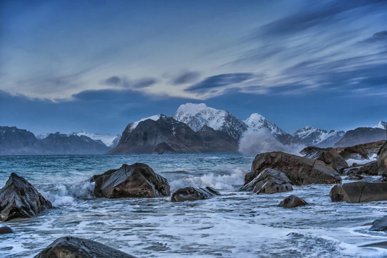 several large rocks out in the ocean with waves crashing