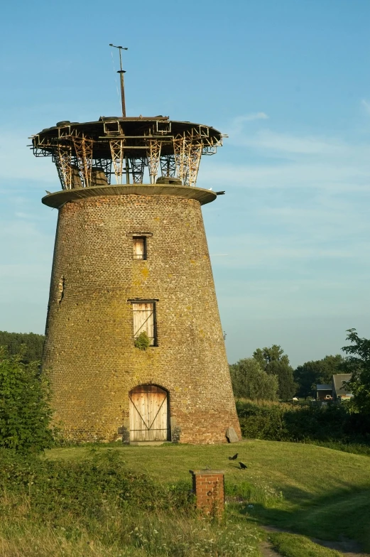 an old wooden water tower sitting in a field