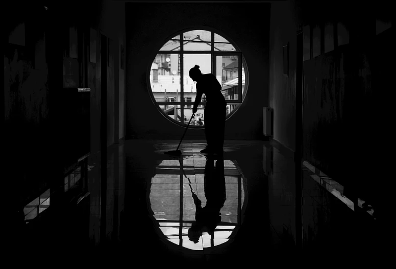 a person standing in a dark hallway in front of a window