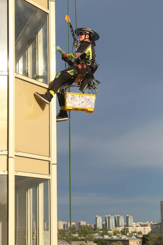 a man that is hanging from a rope with scissors