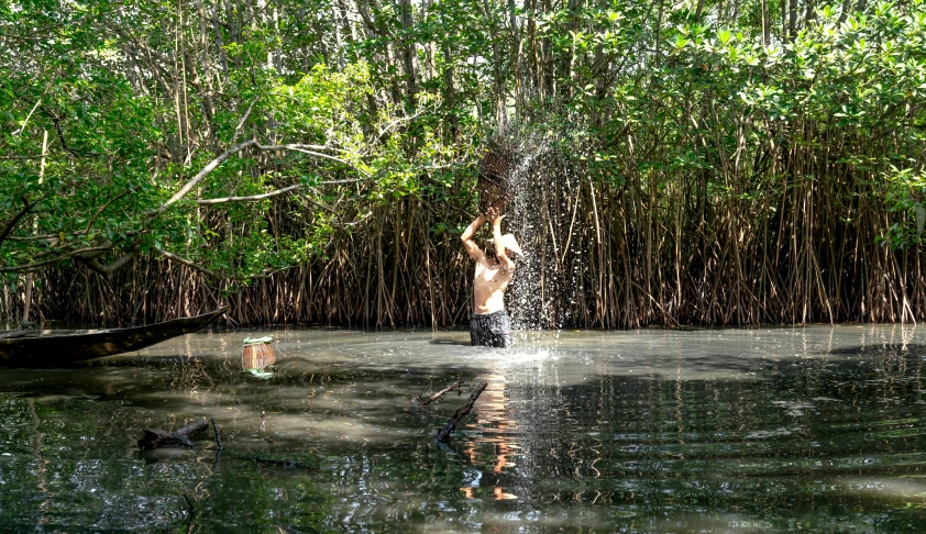 a person splashing water on another person in a boat