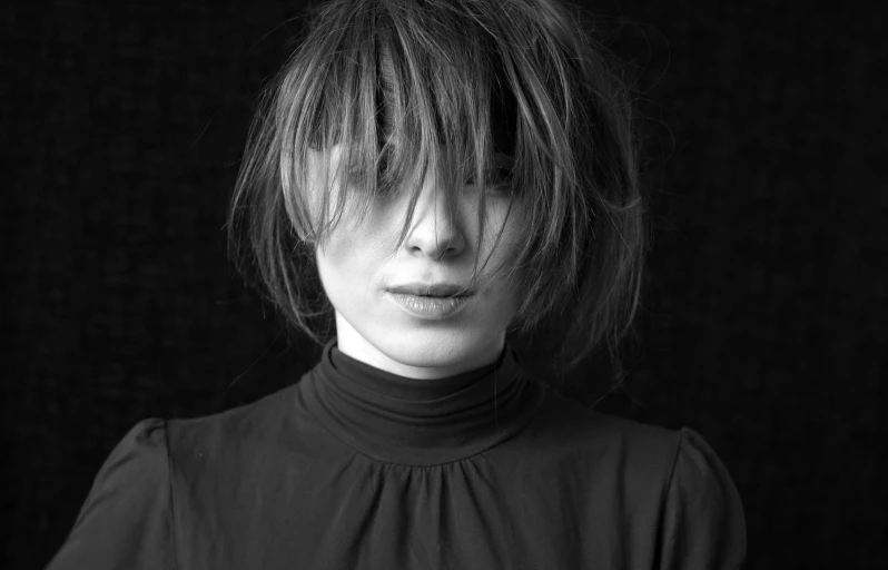woman with a messy haircut and bangs wearing black