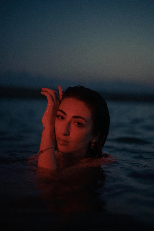 a woman sitting in the ocean on top of a swimming float