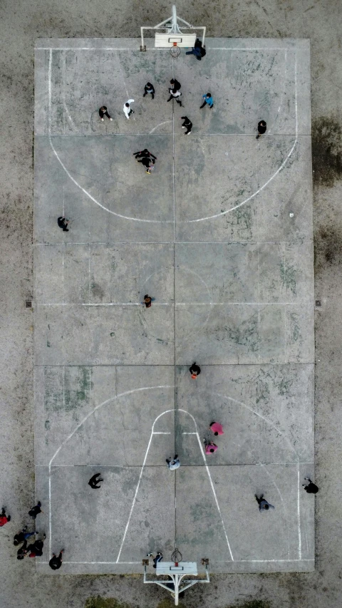 several people are playing basketball on a cement court