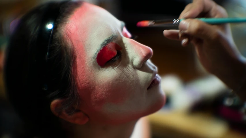 a close up of a person getting makeup painted