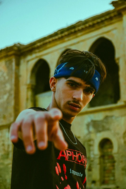 a young man in a black shirt and red print shirt is pointing to the right