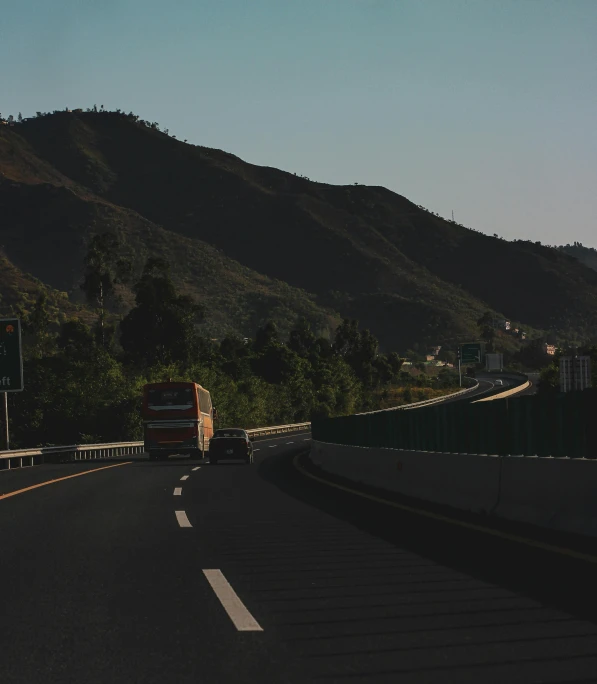 two red trucks on the highway near trees