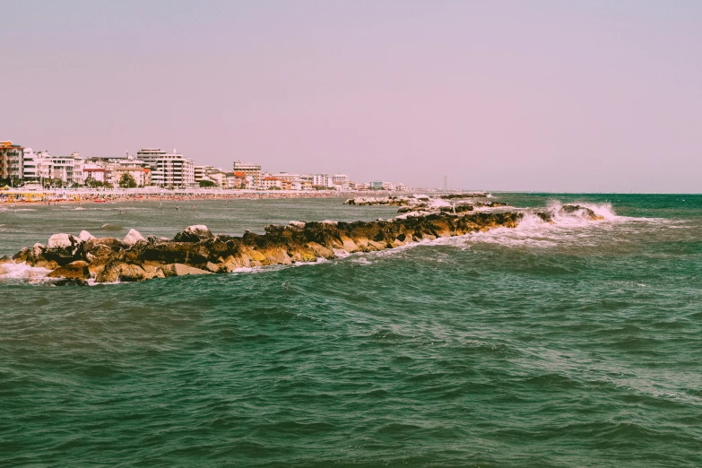 an ocean shoreline with buildings and waves