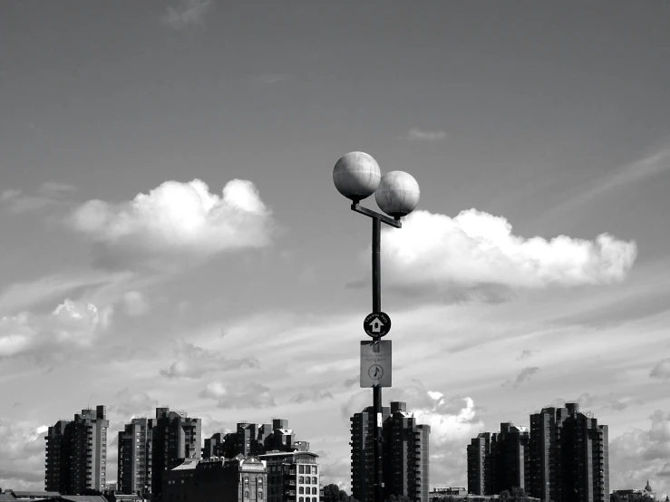 three white light poles that are standing in front of some buildings