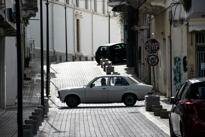 a small white car on a brick street