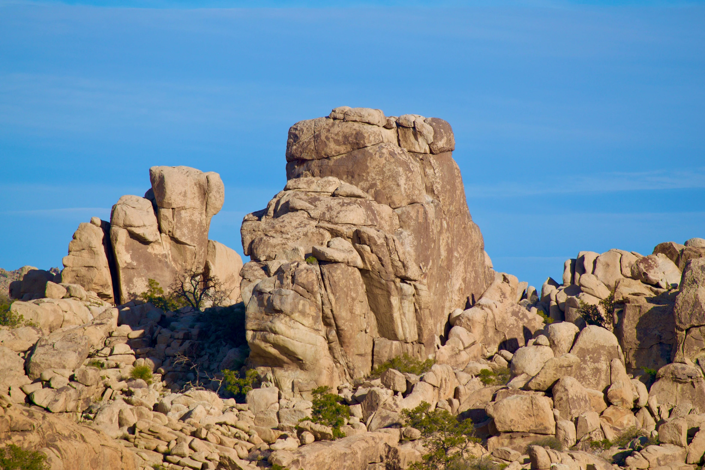 large rock formations in a dry landscape with blue sky