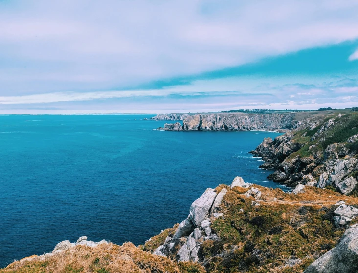 a scenic s of some rocky cliff by the ocean