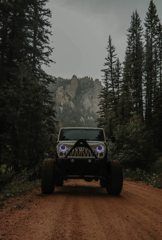 the jeep is on the road near some trees