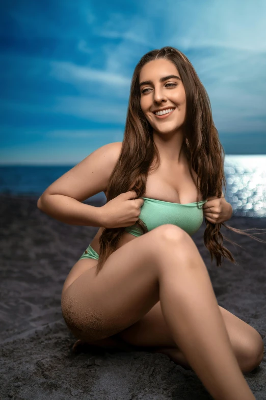 a young woman in a green bikini on a beach
