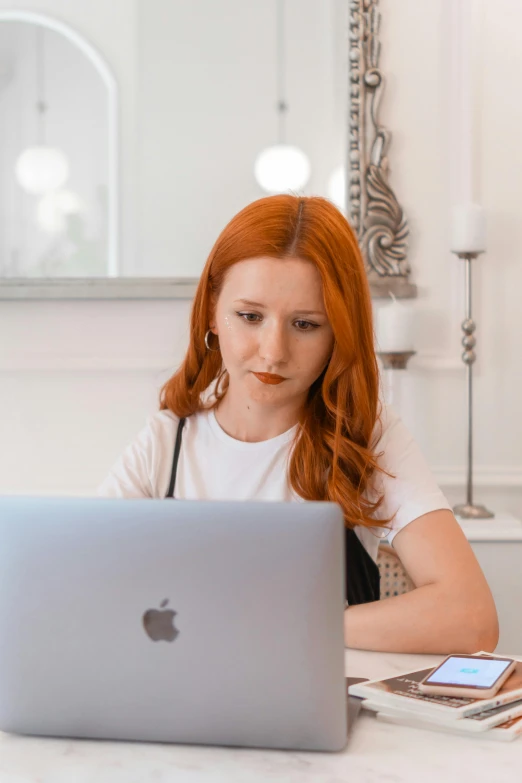 a woman is working on her laptop computer