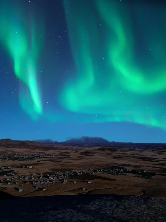 a man is sitting down watching the northern lights