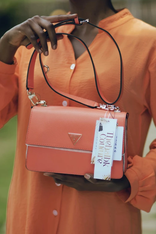 woman holding a pink purse with a name tag on it